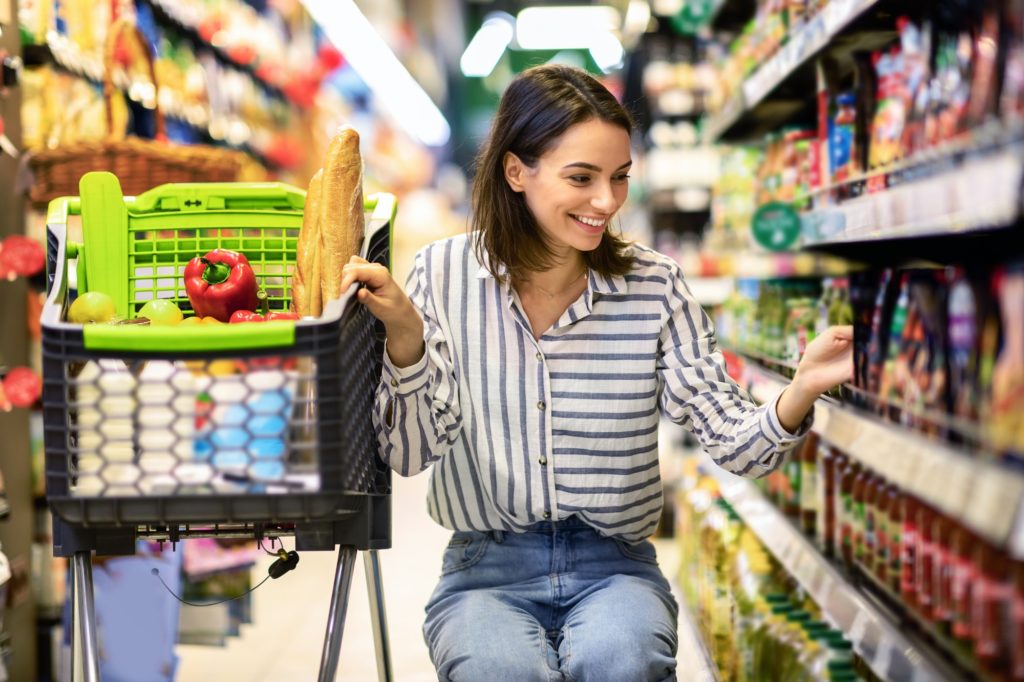 Young woman with the cart shopping in supermarket
